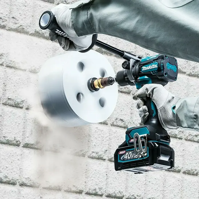Makita XGT 40V max. Taladro atornillador de batería DF001GZ - 40 V, Sin batería - Martillo perforador inalámbrico Makita perforando un agujero en una pared de ladrillo, perfecto para trabajos de construcción pesados.