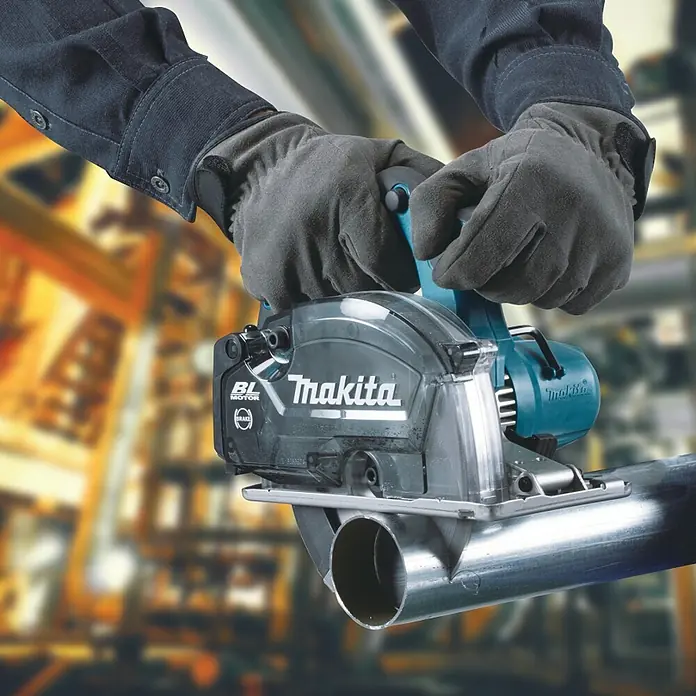 Makita LXT 18V Akku-Handkreissäge DCS553RTJ - 18 V, 2 Akkus, 5 Ah - Nahaufnahme einer Makita Metallsäge beim Schneiden eines Metallrohrs, bedient von Händen in Schutzhandschuhen.