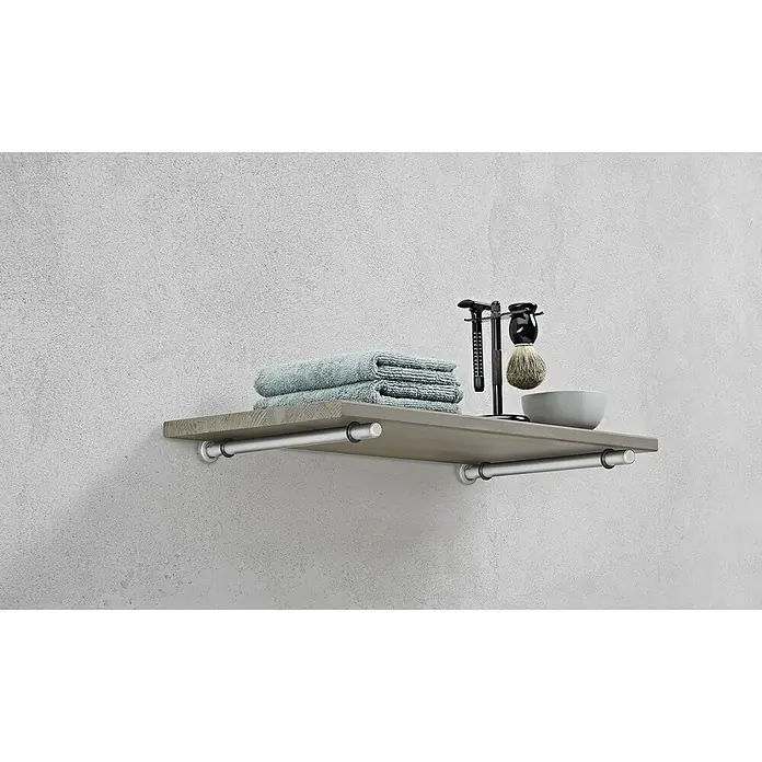Dolle Wandboard Lite Vintage - L x B x S: 80 x 25 x 1,8 cm, Kiefer Grau - Ein graues Regal mit Handtüchern und Rasierutensilien an einer Betonwand, das Badezimmeraccessoires stilvoll präsentiert.