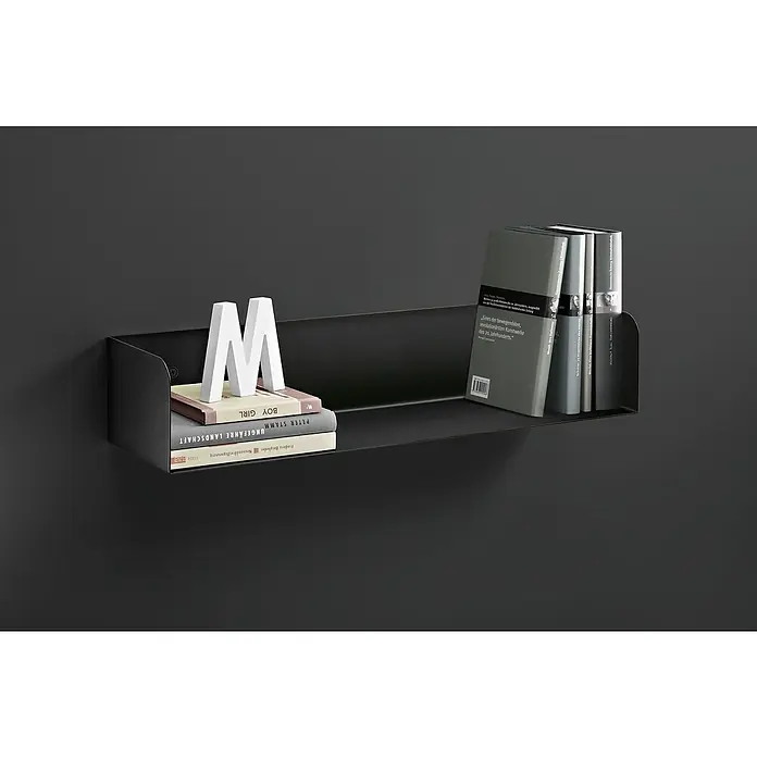 Dolle Wandregal Showcase - L x B x H: 80 x 15 x 11,5 cm, Schwarz, Belastbarkeit: 10 kg, Stahl - Eine stilsichere, schwarze Wandablage mit Büchern und einem weißen "M", die eine elegante und minimalistische Atmosphäre schafft.