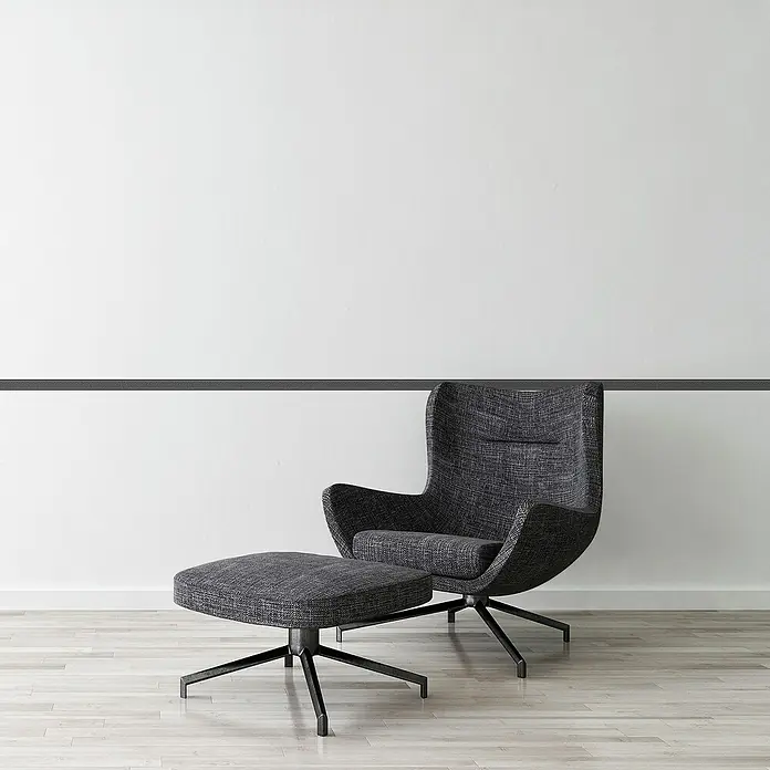A.S. Création Only Borders 11 Tapetenborte Mäander - Schwarz, 5 x 0,04 m, Selbstklebefolie - Elegantes Anthrazitfarbenes Sessel- und Fußhocker-Set vor einer schlichten Wand. Die moderne Formgebung macht es zu einem Blickfang in jedem Raum.