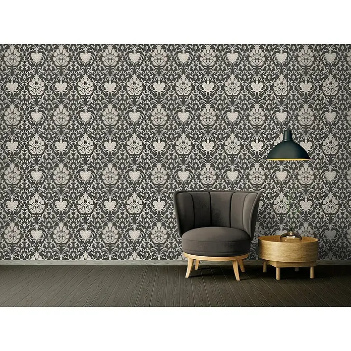 A.S. Création Vliestapete Ornament - Schwarz Glitzer, L x B: 10,05 x 0,53 m - Elegante Inneneinrichtung mit stilvollem Sessel, Beistelltisch und Pendelleuchte vor einer gemusterten Tapete.