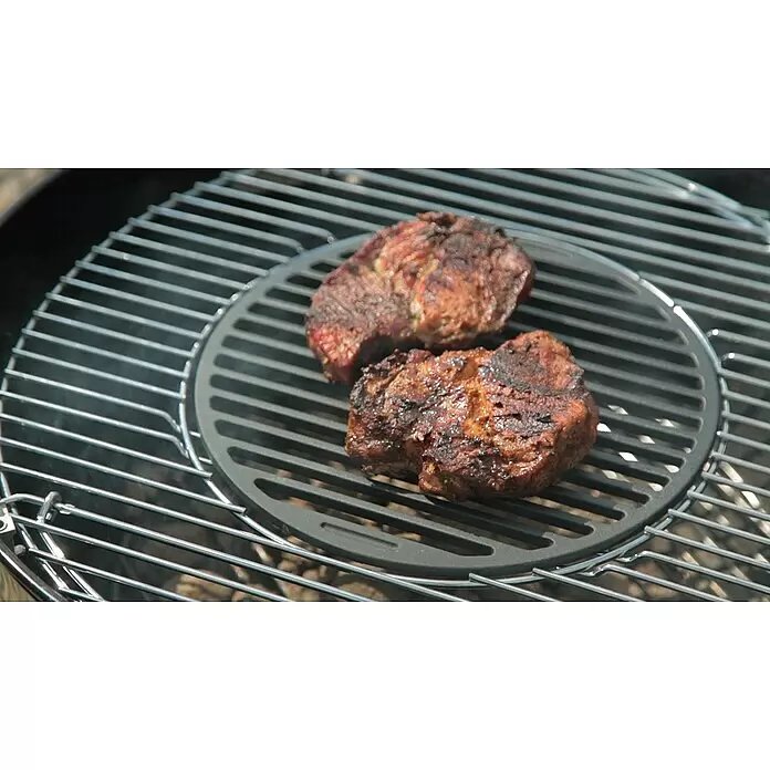 Tepro Grillrost - Durchmesser: 30,5 cm - Runder, dunkler Gusseisen-Grilleinsatz mit zwei angebratenen Fleischstücken darauf.