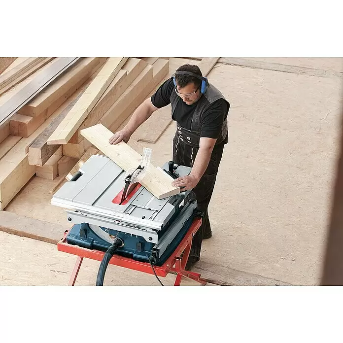 Bosch Professional Tischkreissäge GTS 10 XC - 2.000 W, Durchmesser Sägeblatt: 254 mm, Schnitttiefe bei 90 °: 79 mm - Mann sägt Holzbrett mit einer Tischkreissäge mit Schutzvorrichtung und Absaugung.