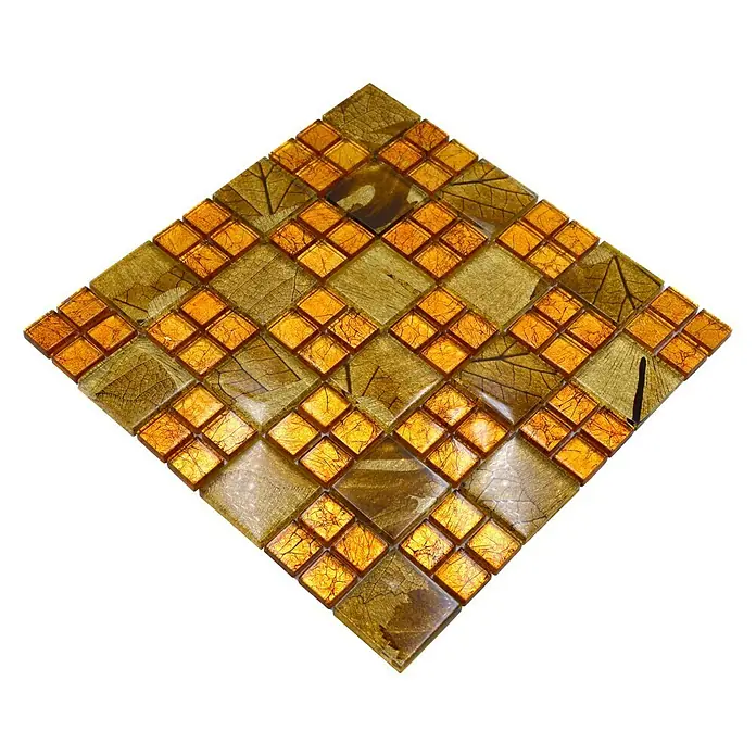 Mosaikfliese Crystal Desert XCM 8DSG - 30 x 30 cm, Gold, Glänzend - Nahaufnahme eines quadratischen Mosaiks aus goldenen und bernsteinfarbenen Glasfliesen mit Blattmuster auf schwarzem Hintergrund.