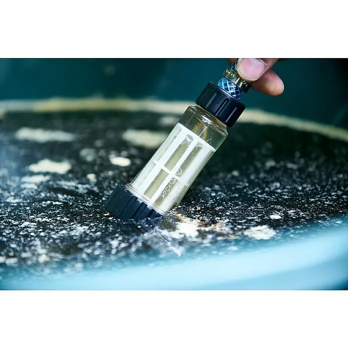 Nilfisk Wassereinlassfilter - Kunststoff - Eine transparente Inline-Filterkartusche für die Wasserreinigung wird in einem blauen Wasserbehälter verwendet.