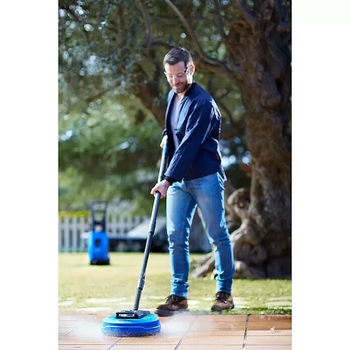 Nilfisk Limpiadora de superficies Power Patio - Específico para: Limpiadoras de alta presión Nilfisk - Hombre usando un accesorio limpiador de superficies azul y negro para lavar a presión un patio.