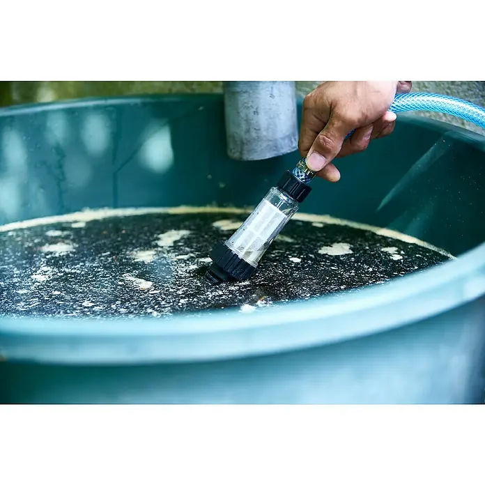 Nilfisk Wassereinlassfilter - Kunststoff - Nahaufnahme eines Wasserfilters, der in einen Behälter mit Flüssigkeit getaucht wird, verbunden mit einem blauen Schlauch.
