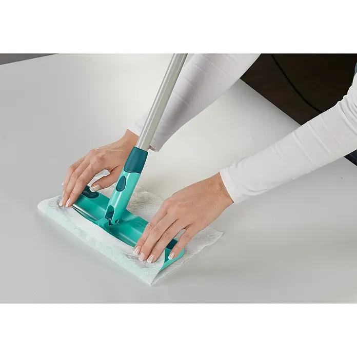 Leifheit Set de mopa atrapapolvos Clean & Away - Ancho: 22 cm - Una persona sujeta un paño de limpieza al limpiaparabrisas Leifheit, un dispositivo de limpieza de suelos con mango telescópico y cabezal de fregona verde.