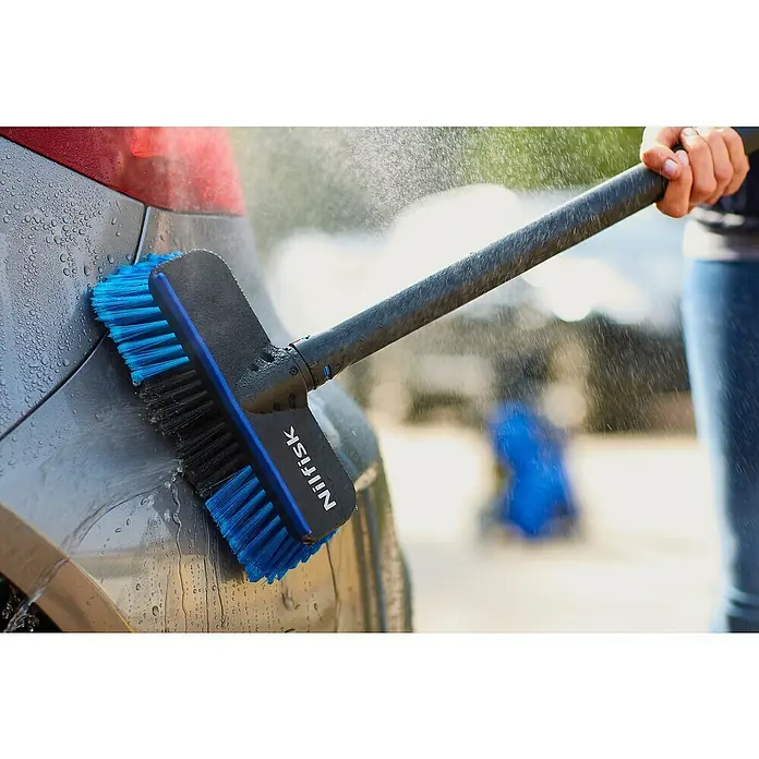 Nilfisk Cepillo para automóviles - Específico para: Limpiadoras de alta presión Nilfisk - Un cepillo de lavado Nilfisk con cerdas azules y negras se utiliza para limpiar un coche con agua, prometiendo limpieza y eficiencia.