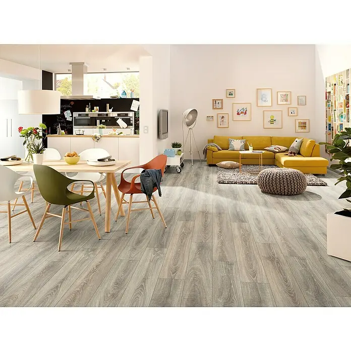 Laminat - Leonessa, Landhausdiele, 1.292 x 193 x 7 mm - Helles, modernes Interieur mit Fokus auf dem grauen Holzboden, der dem Raum Wärme und Stil verleiht. Einladendes Design für Wohn- und Essbereich.