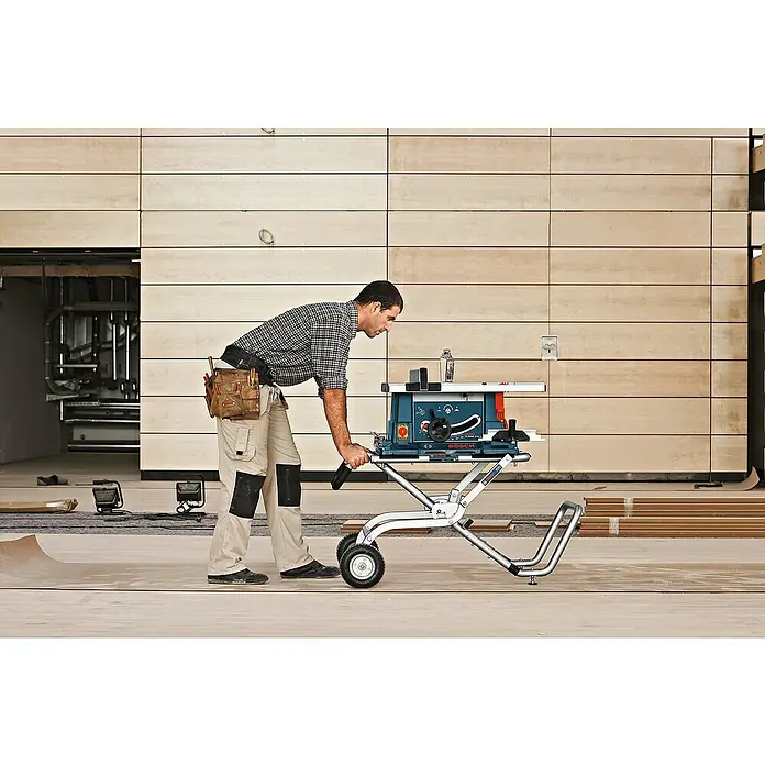 Bosch Professional Werkbank GTA 60 W - Arbeitshöhe: 622 mm, Belastbarkeit: 180 kg - Ein Handwerker bedient eine Bosch Tischkreissäge auf einem Rollwagen in einer Baustelle.