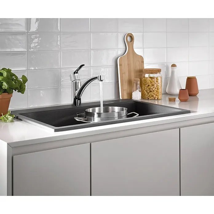 Grohe QuickFix Spültischarmatur Start - Ausladung Armatur: 227 mm, Chrom, Schwenkbereich: 140 ° - Eine moderne Küche mit einer stilvollen schwarzen Spüle, einer Armatur und Küchenutensilien auf der Arbeitsplatte.