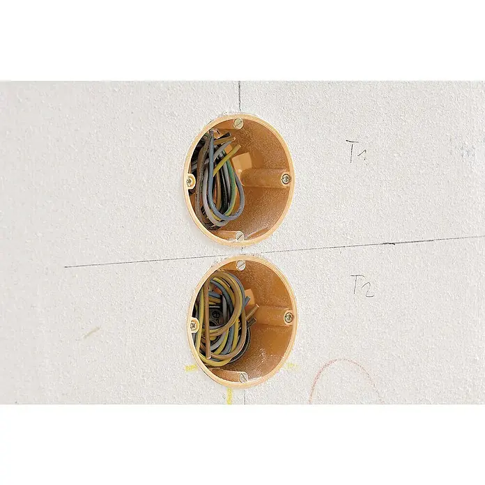 Wolfcraft Plantilla de perforación - 185 x 50 mm, Apto para: Cajas para empotrar - Dos cajas de conexión redondas y naranjas en una pared blanca con cables y tornillos visibles, etiquetadas como "T1" y "T2".