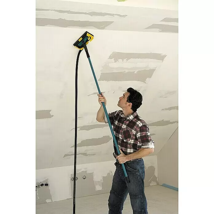 Wolfcraft Lijadora de pared y techo - Diámetro disco de lija: 225 mm - Lijadora de mango largo amarilla y azul con manguera de extracción de polvo, utilizada por un hombre para alisar un techo.
