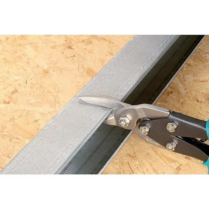 Wolfcraft Blechschere - Länge: 255 mm, Gerade - Blechschere schneidet ein Metallprofil auf einem Holzboden, wobei die Funktionalität und Präzision des Werkzeugs im Vordergrund stehen.