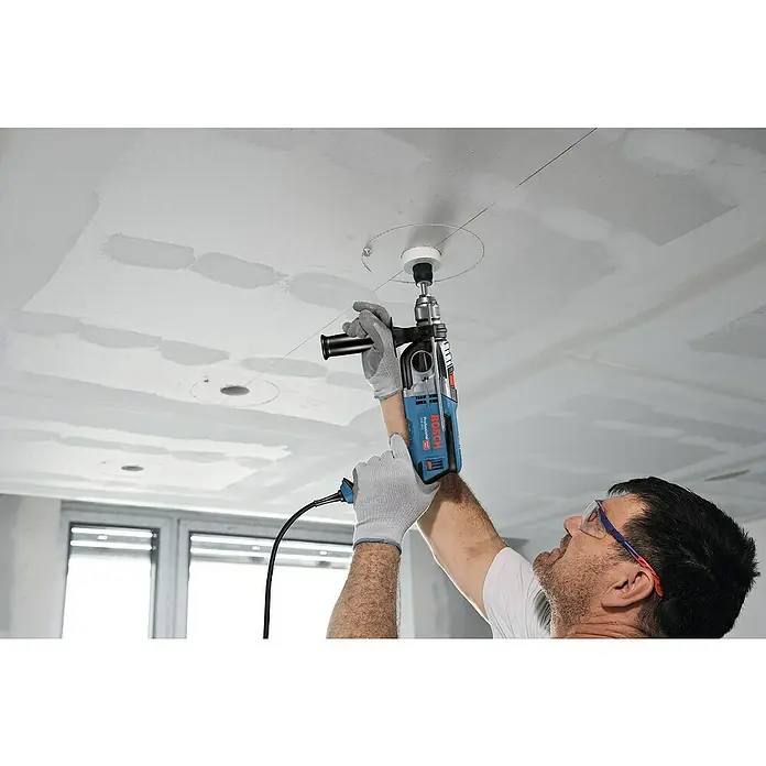 Bosch Professional Schlagbohrmaschine GSB 20-2 - 850 W, Schnellspannbohrfutter - Mann bohrt mit einer blauen Bosch Schlagbohrmaschine ein Loch in die Decke, um einen Scheinwerfer zu installieren.