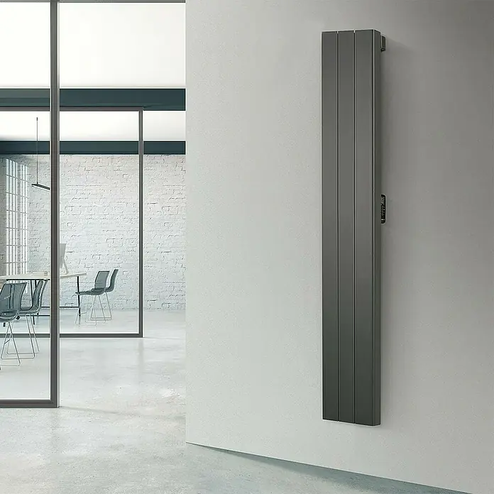 Rointe Radiador eléctrico digital Palaos - 1.500 W, Negro, 110 x 356 x 1.800 mm - Radiador gris sobre pared blanca, que proporciona calidez y un diseño moderno. Perfecto para interiores elegantes y calefacción eficiente.