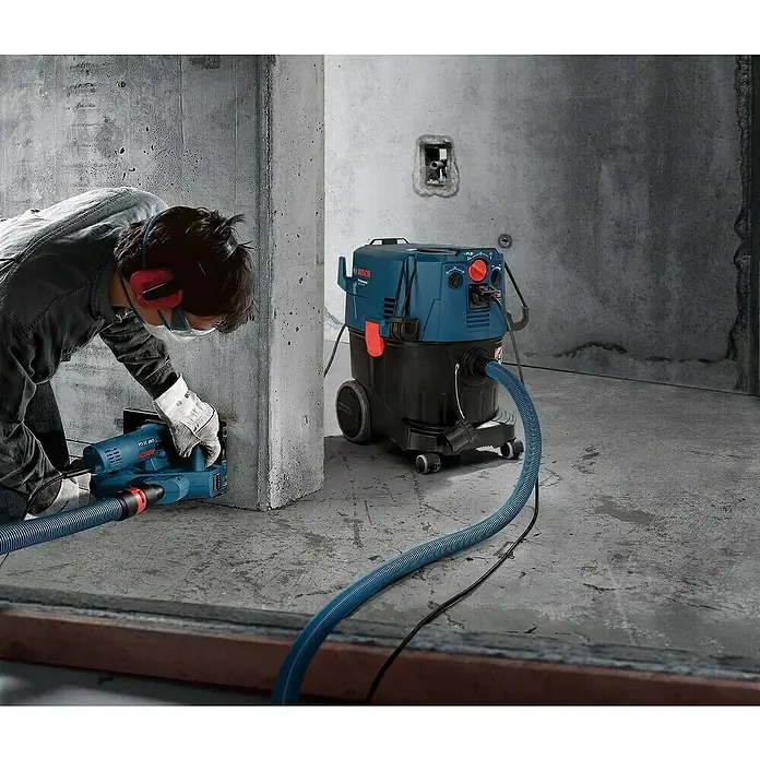 Bosch Professional Elektro-Nass- & Trockensauger GAS 35 H AFC - 1.200 W, 35 l - Ein Bauarbeiter benutzt eine Mauernutfräse, die an einen Bosch Industriesauger angeschlossen ist, um Staub zu entfernen.