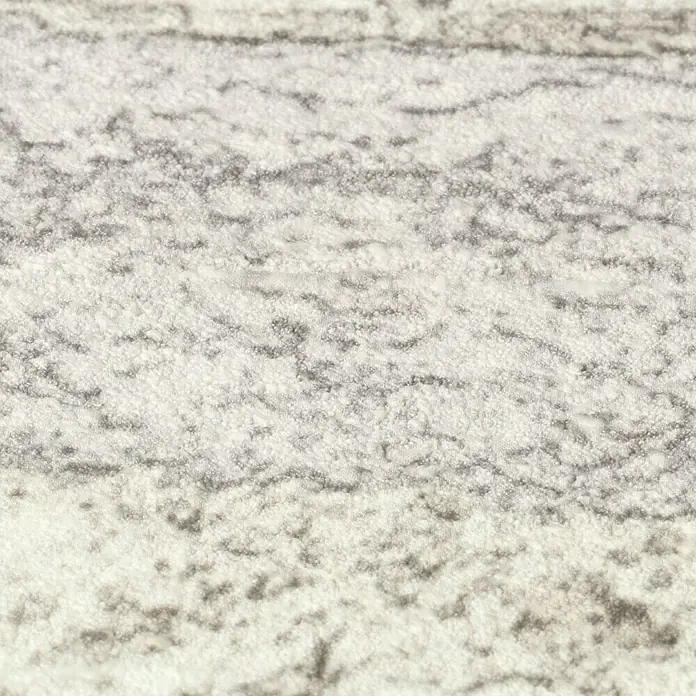 Rasch Factory 4 Vliestapete Steinmauer - Weiß, Steinoptik, 10,05 x 0,53 m - Nahaufnahme eines stilvollen Teppichs mit einem einzigartigen, verschwommenen Muster in neutralen Farbtönen, ideal für moderne Wohnräume.