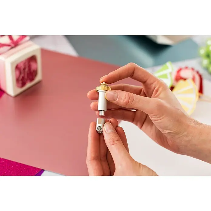 Cricut Maker Plotter-Werkzeug Rill- & Falz-Werkzeug Quickswap - Passend für: Cricut Maker Schneideplotter - Nahaufnahme von Händen, die eine Cricut-Feinschnittklinge halten, die sich für präzise Schneidearbeiten eignet. Ideal für DIY-Enthusiasten.