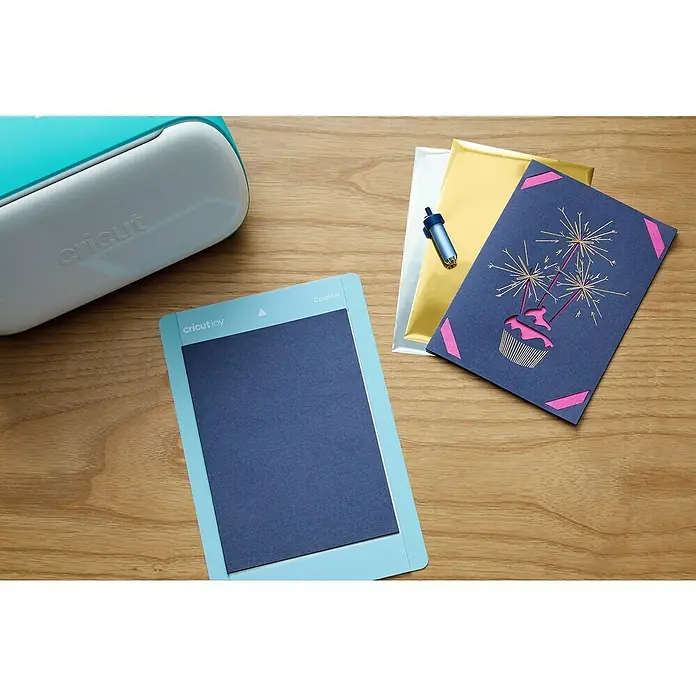 Cricut Joy Plotter-Werkzeug Folientransfer-Werkzeug - Passend für: Cricut Joy Schneideplotter - Nahaufnahme eines Cricut Joy DIY-Bastelsets mit Maschine, Schneidematte, Werkzeug und Geburtstagskarte auf einem Holztisch.