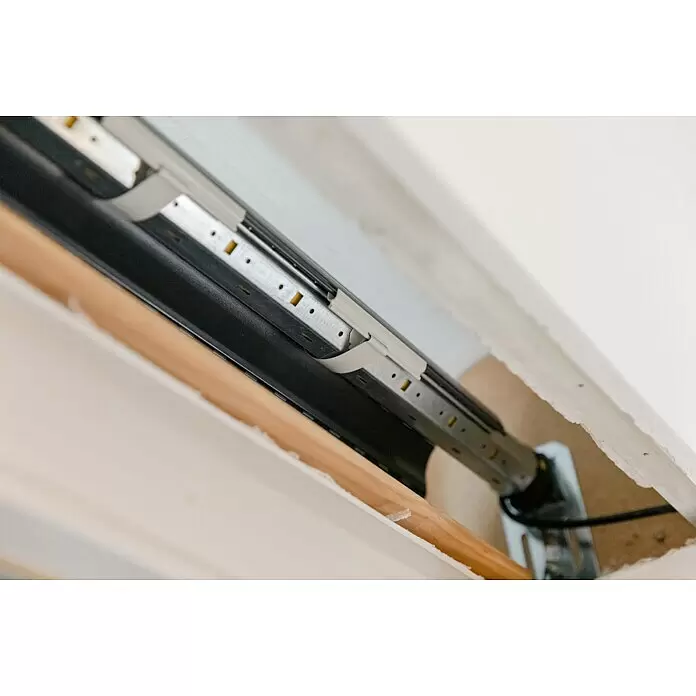 Schellenberg Eje octogonal Maxi - 60 mm x 1,5 m, Apto para: Maxi sistemas de persianas enrollables - Vista interna de un mecanismo de persiana enrollable con tubo negro, riel metálico y clips de plástico blancos.