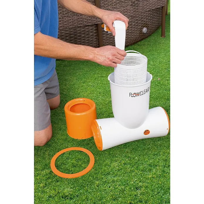 Bestway Flowclear Einhängeskimmer 2 in 1 - 73 W, Filterleistung: 3.974 l/h - Bild von einem Flowclear Pool Filter, der auf grünem Gras steht und von einer Person bedient wird.