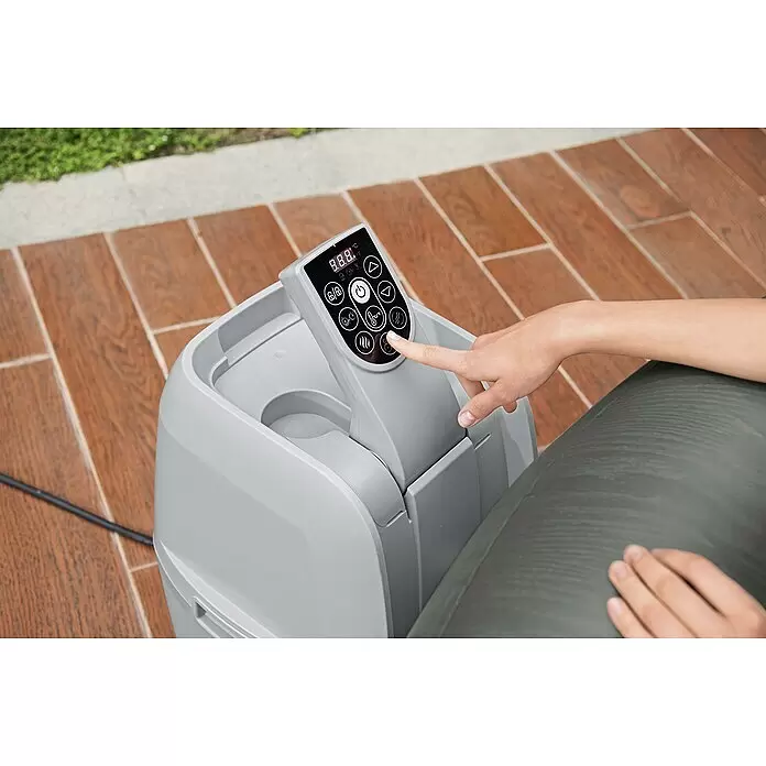 Bestway Lay-Z-Spa Mobil-Whirlpool Mauritius Airjet - Braun, 1.370 l - Eine Hand drückt einen Knopf auf einem grauen Spa-Bedienfeld mit Digitalanzeige und verschiedenen Funktionssymbolen.