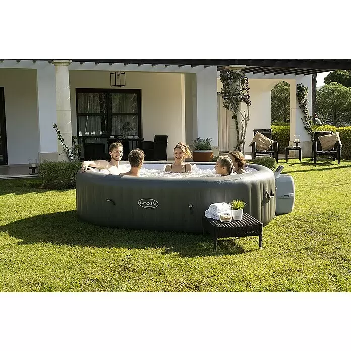 Bestway Lay-Z-Spa Mobil-Whirlpool Mauritius Airjet - Braun, 1.370 l - Fünf Personen entspannen in einem grauen aufblasbaren Lay-Z-Spa Mauritius Whirlpool, aufgestellt auf einem grünen Rasen im Garten.
