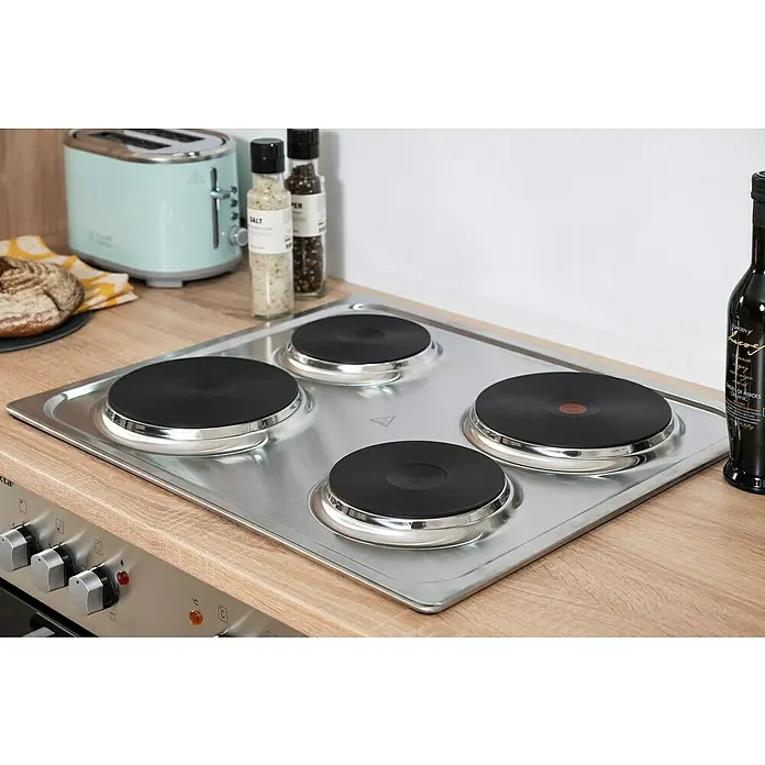 Respekta Singleküche Merle Typ 1 - Breite: 240 cm, Schwarz, Mit Elektrogeräten, Volumen Backofen: 60 l - Nahaufnahme eines silbernen Elektroherds mit vier Kochplatten, eingebaut in eine hölzerne Arbeitsfläche. Praktisches und modernes Küchendesign.