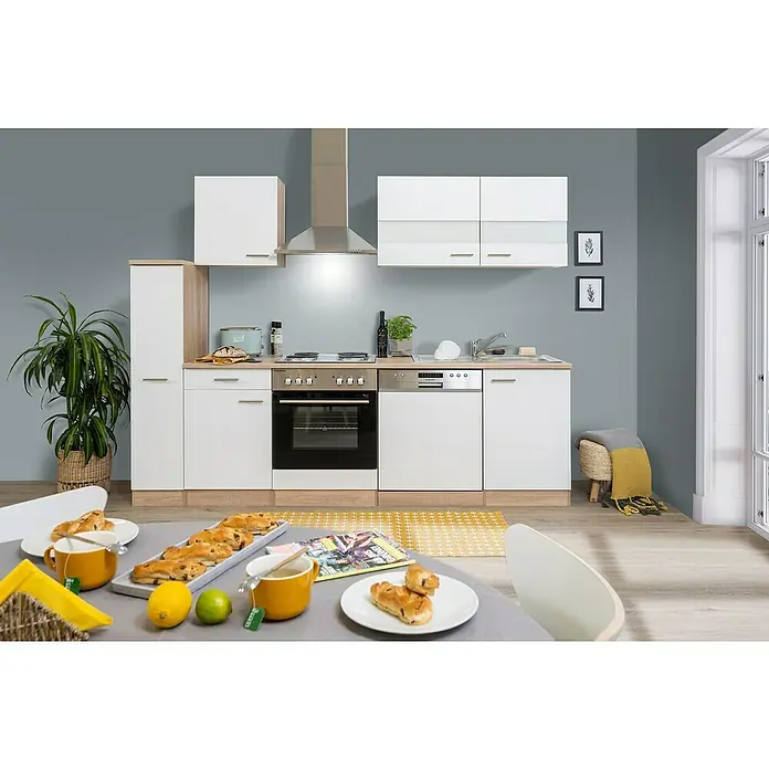 Respekta Singleküche Merle Typ 1 - Breite: 250 cm, Weiß, Mit Elektrogeräten, Volumen Backofen: 60 l - Küchenansicht mit weißen Schränken, Edelstahlgeräten und einem gedeckten Tisch mit Gebäck, Zitronen und Tee.