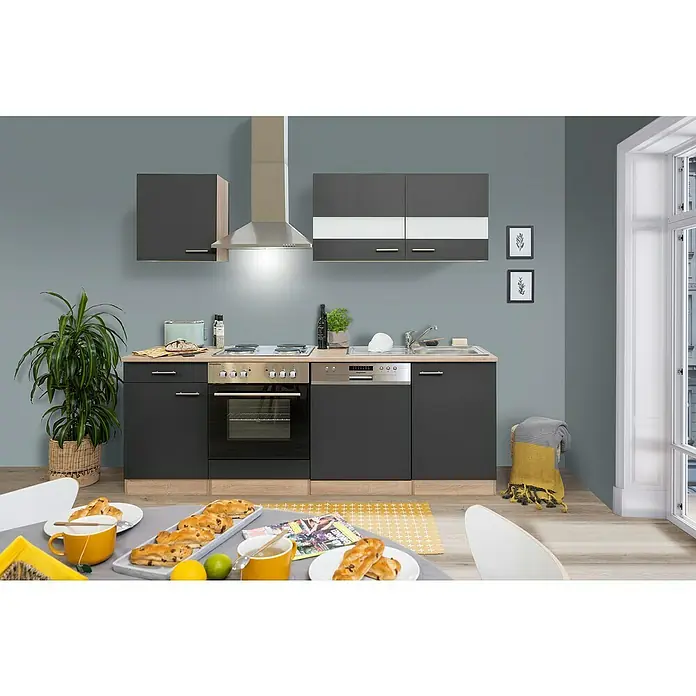 Respekta Singleküche Merle Typ 1 - Breite: 220 cm, Grau, Mit Elektrogeräten, Volumen Backofen: 60 l - Eine moderne, graue Küchenzeile mit Hängeschränken, einer Dunstabzugshaube und einem Esstisch mit Gebäck.