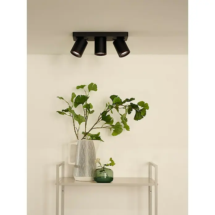 Lucide Deckenstrahler Nigel - 15 W, L x B x H: 30 x 10 x 11,5 cm, Schwarz, GU10 - Eine moderne, schwarze Deckenleuchte mit drei Strahlern beleuchtet stilvoll den Raum. Die Zimmerpflanze sorgt für eine gemütliche Atmosphäre.