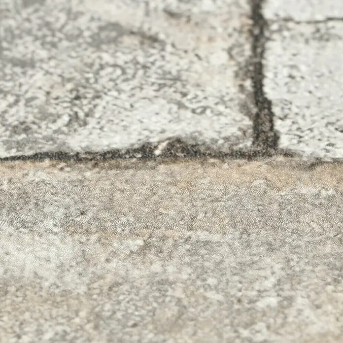 Rasch Vliestapete Factory 2 - Creme, Steinoptik, 10,05 x 0,53 m - Nahaufnahme einer grauen Backsteinoberfläche, die eine rustikale und robuste Textur zeigt. Ideal für Hintergründe oder Designelemente.