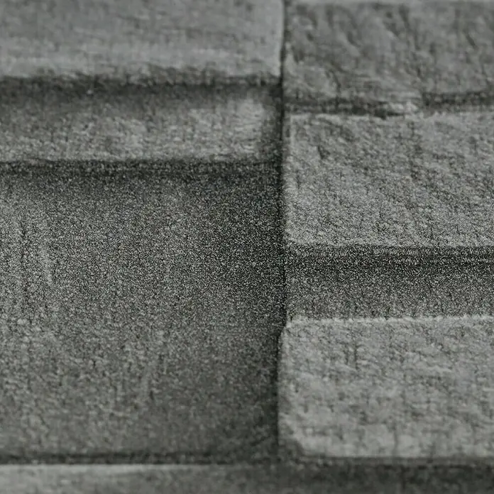 Rasch Vliestapete Steinoptik - Grau/Silber/Schwarz, 3D-Optik, 10,4 x 0,53 m - Nahaufnahme einer grauen Mauer mit strukturierter Oberfläche. Die Ziegelsteine haben eine unebene Textur und sind in einem dunklen Grauton gehalten.