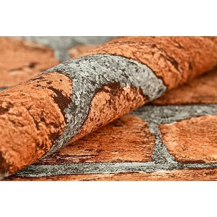 Rasch Vliestapete Stein - Rot/Grau, Steinoptik, 10,05 x 0,53 m - Nahaufnahme einer Rolle Mauerwerktapete in warmen Farben und Grautönen, die eine realistische Backsteinoptik für Innenräume bietet.