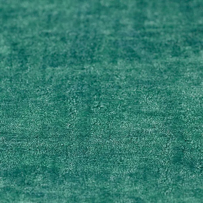 Rasch Factory 4 Vliestapete - Blau/Grün, Uni, 10,05 x 0,53 m - Nahaufnahme eines smaragdgrünen Teppichs mit einer feinen, strukturierten Oberfläche, die eine weiche und luxuriöse Textur andeutet.