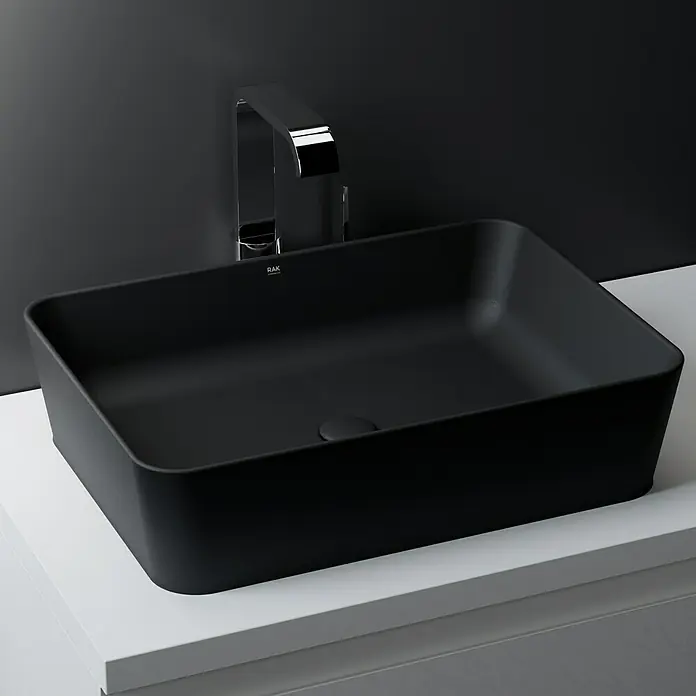 RAK Ceramics Feeling Ablaufventil - 1 ¼″, Schwarz, Mit Druckknopf - Hier ist ein modernes Waschbecken in elegantem Schwarz mit einer Armatur, die das minimalistische Design des Produkts hervorhebt.