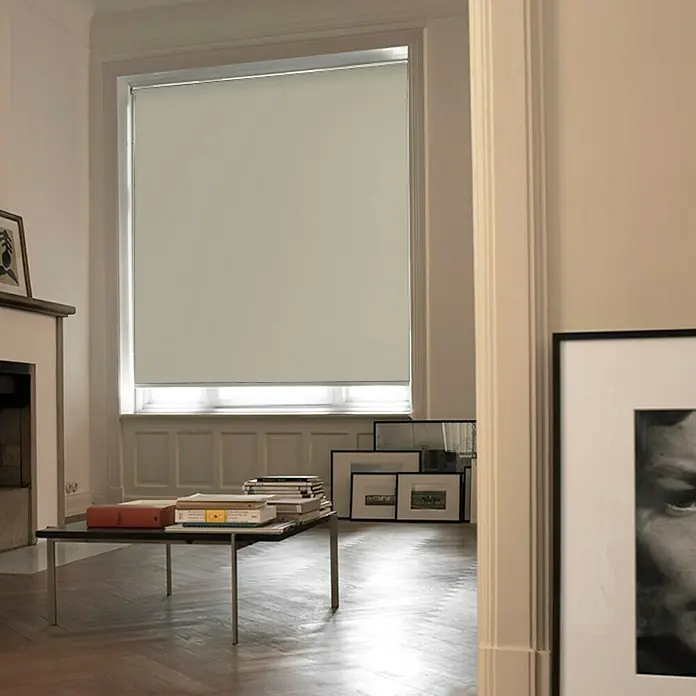 Estor enrollable opaco Liso - An x Al: 90 x 250 cm, Beige - Un estor enrollable en una habitación luminosa, con pilas de libros sobre una mesa, ofreciendo privacidad y luz difusa.