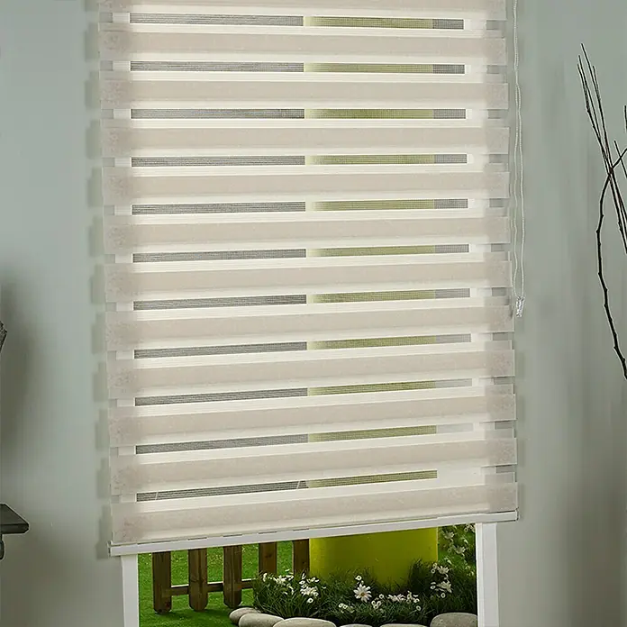 Estor noche y día Martina - An x Al: 200 x 250 cm, Lino - Esta foto captura un primer plano de persianas enrollables dobles con rayas beige y transparentes, montadas frente a una ventana con vistas a un jardín.