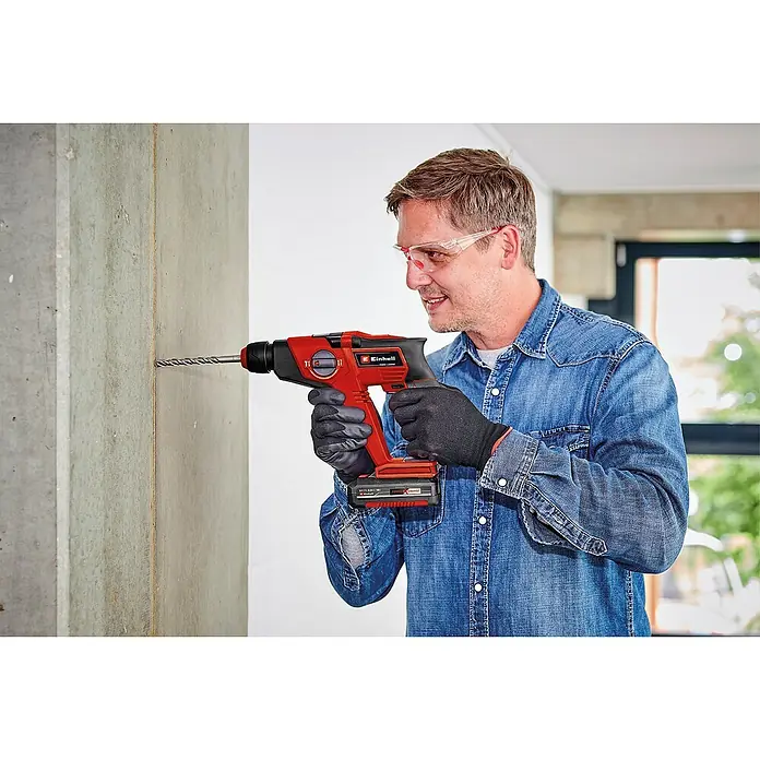 Einhell PXC 18V Martillo perforador de batería TE-HD 18/12 Li - Solo - 18 V, Sin batería, 1,3 J - Un hombre perfora una pared con un martillo perforador inalámbrico Einhell. Ideal para los amantes del bricolaje que valoran la calidad.