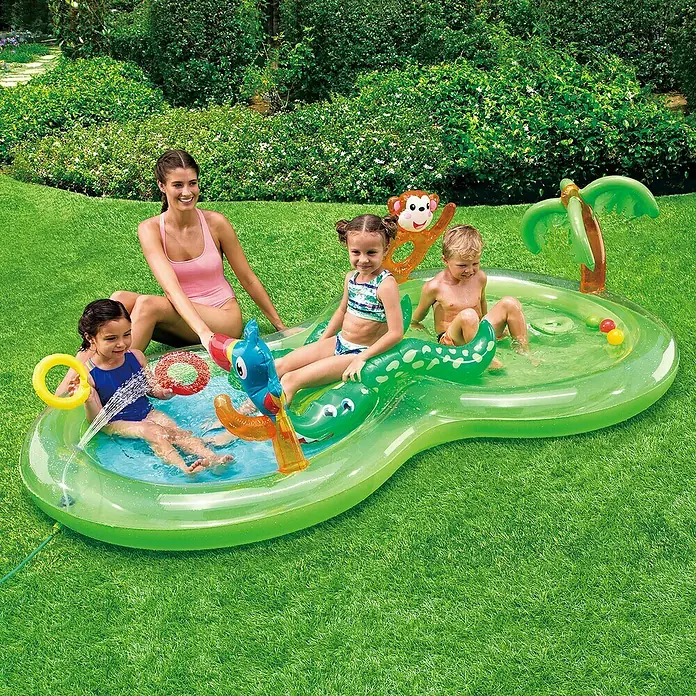 Planschbecken Jungle Play Center - L x B x H: 257 x 145 x 61 cm, Grün - Ein aufblasbares Planschbecken im Dschungeldesign mit aufblasbaren Tieren, in dem eine Frau und drei Kinder Spaß haben.