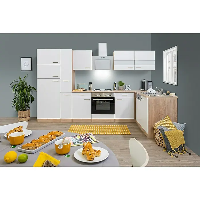 Respekta Winkelküche Merle - B x T: 310 x 172 cm, Weiß, Mit Elektrogeräten, Volumen Backofen: 60 l - Küchenszene mit weißen Schränken, Holzdetails und einem Esstisch mit Gebäck und Tee. Eine moderne und einladende Küchengestaltung.