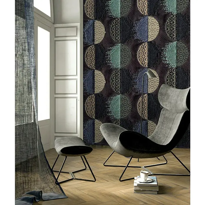 Komar Ink Fototapete Moon Dance - 4 -tlg., B x H: 200 x 280 cm, Vlies - Ein modernes Wohnzimmer mit einem grauen Sessel und Hocker, dekoriert mit einer auffälligen Wandtapete mit Kreismustern in verschiedenen Farben.