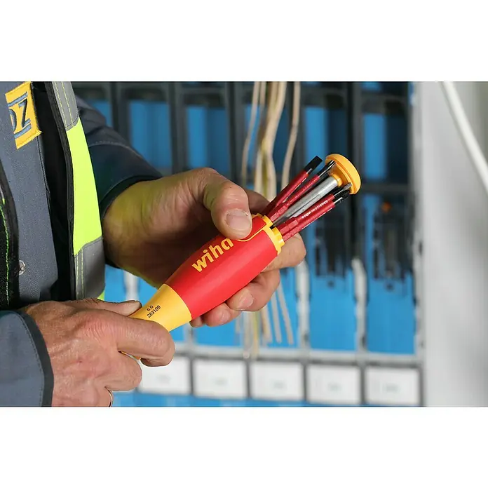Wiha Schraubendreher-Set LiftUp electric - 7 -tlg. - Ein Elektriker hält einen Wiha Mehrfach-Schraubendreher mit verschiedenen Aufsätzen in der Hand. Das Werkzeug ist rot und gelb.