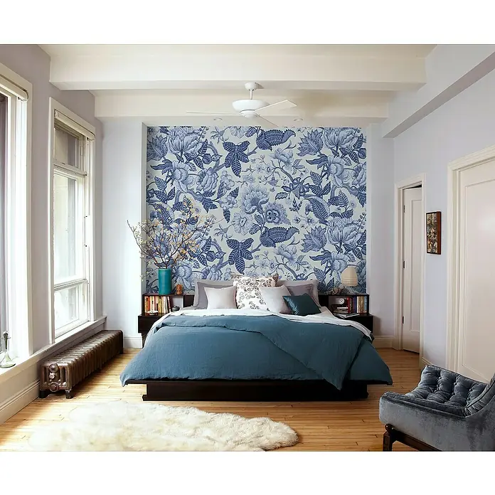 Komar Ink Fototapete Bleuet - 4 -tlg., B x H: 200 x 280 cm, Vlies - Einladendes Schlafzimmer mit blau-weiß gemusterter Tapete, gemütlichem Bett mit blauer Decke und einem einladenden Sessel.