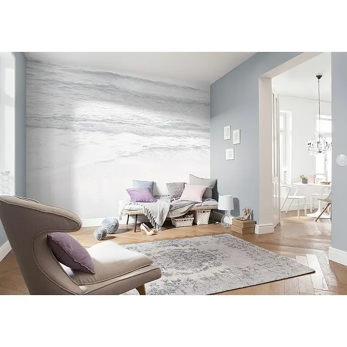 Komar Raw Fototapete Silver Beach4 -tlg., B x H: 400 x 280 cm, Vlies - Elegantes Wohnzimmer mit einem stilvollen Sessel, einem dekorativen Teppich und einer beruhigenden Fototapete, die eine entspannende Atmosphäre schafft.