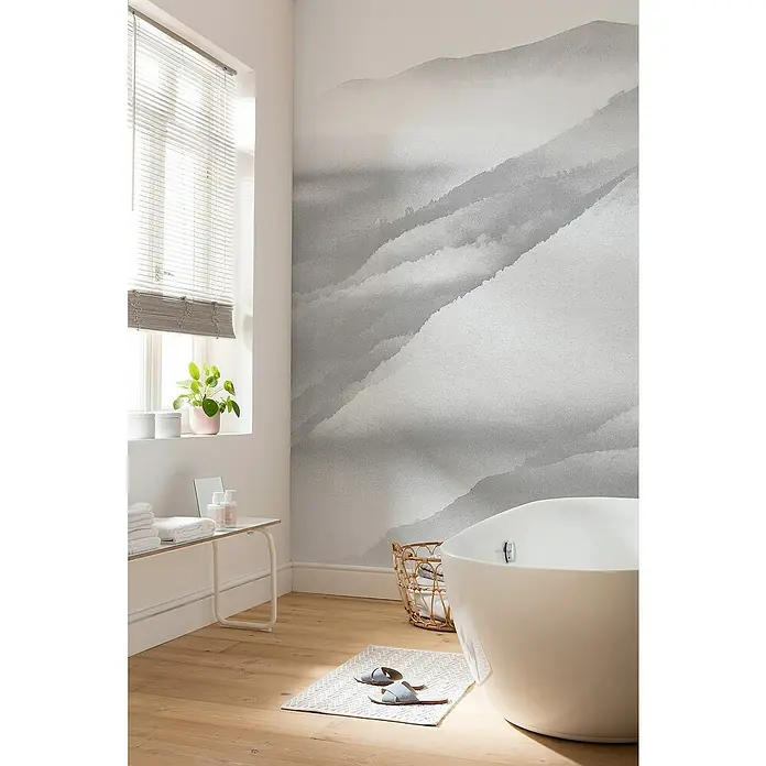 Komar Raw Fototapete White Noise Mountain - 2 -tlg., B x H: 200 x 280 cm, Vlies - Elegantes Badezimmer mit einem freistehenden, weißen Bad, einer Akzentwand mit Bergmotiv und einem hellen Holzboden.