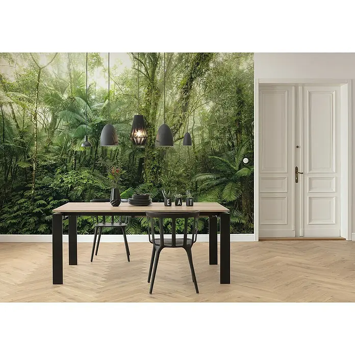 Komar Home Fototapete Mindfulness - 7 -tlg., B x H: 350 x 250 cm, Vlies - Ein Esszimmer mit einem Esstisch und Stühlen vor einer Wandtapete mit Dschungelmotiven. Die Hängelampen runden das Bild ab.
